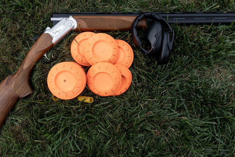 McCloys shooting sports Over-and-under shotgun with clay pigeons and hearing protection